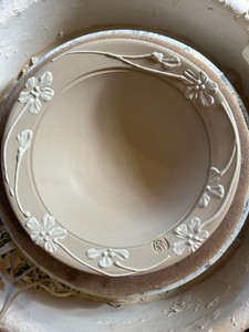 unfired stoneware bowl with floral design on rim